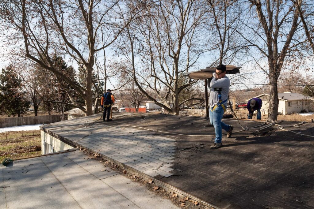 Palmer Roofing roofers working on a residential roofing project in Pasco, WA, with roofers installing tiles and ensuring high-quality workmanship.